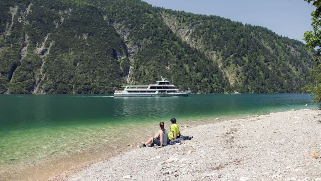 Zwei Personen am Achensee mit Boot im Hintergrund, Tirol.